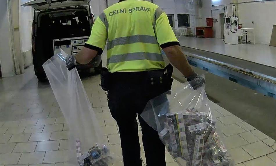 celník táhne pytel s cigaretami